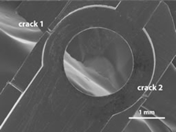 An image of the damaged High Tilt Retainer (HTR) showing two cracks magnified at 1 mm.