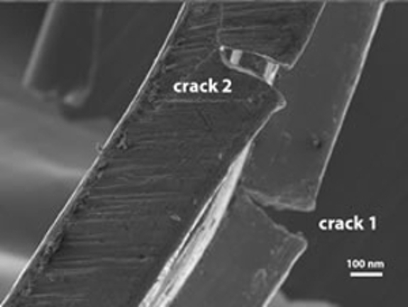 An image of the damaged High Tilt Retainer (HTR) showing two cracks magnified at 100 nm.